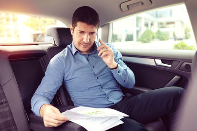 Full length of man sitting in car