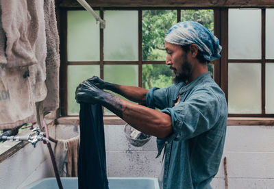 Side view of man working at window