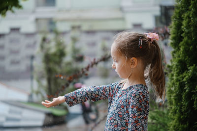 Side view of young woman standing in city