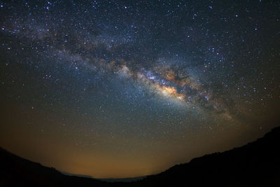 Scenic view of silhouette mountain against star field at night