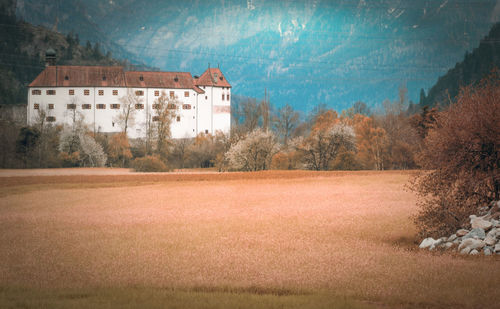 Old building by field against sky