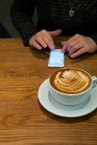 Midsection of woman holding coffee cup