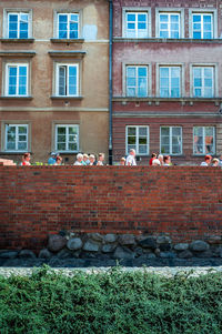 People on brick wall of building