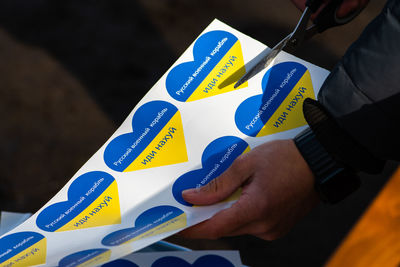 Preparing stickers heart shape with colors of ukraine during a peaceful demonstration against war