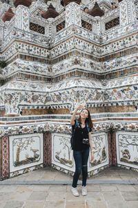 Full length of woman standing against historic building