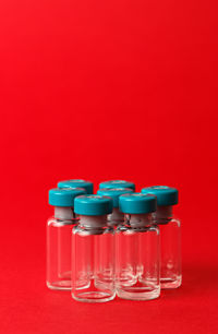 Close-up of glasses on table against red background