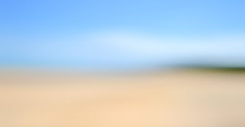 Defocused image of field against clear blue sky