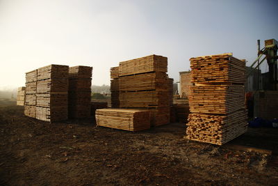 Stack of logs on field against clear sky