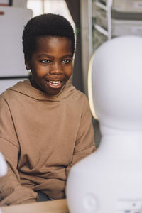 Curious boy looking at ai social robot in innovation lab