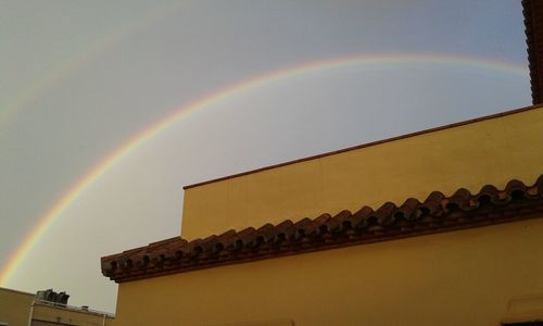 Low angle view of rainbow over buildings