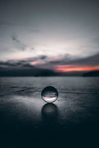 Close-up of water on beach against sky during sunset