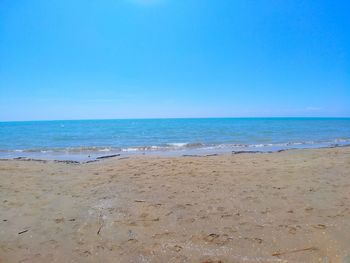 Scenic view of beach against clear blue sky