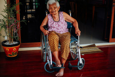 Portrait of young woman sitting on wheelchair