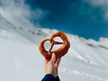 Cropped hand of woman holding snow