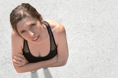 Portrait of young woman standing against wall