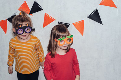 Two smiling girls in carnival masks for halloween. children look away with joy in their eyes.