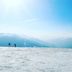 People on snowcapped mountains against sky