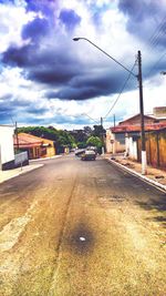 Empty road against cloudy sky