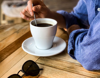 Low section of woman using mobile phone on table