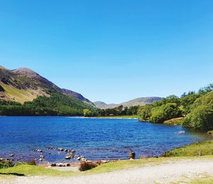 Scenic view of lake against clear blue sky