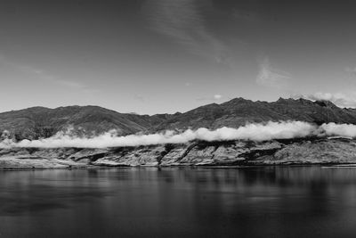 Scenic view of lake and snowcapped mountains against sky