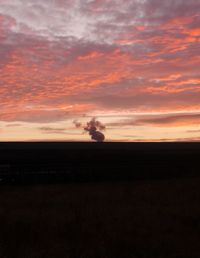 Scenic view of landscape against orange sky