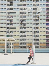 Full length of woman standing against buildings in city