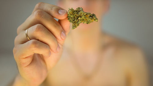 Midsection of man holding marijuana