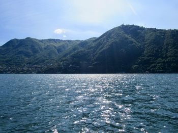 Scenic view of sea and mountains against sky