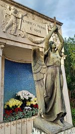 Low angle view of angel statue against wall