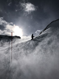 Low angle view of man against sky during winter