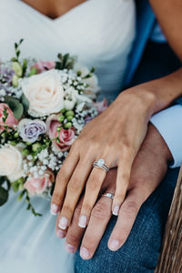 Midsection of newlywed couple holding hands in wedding ceremony