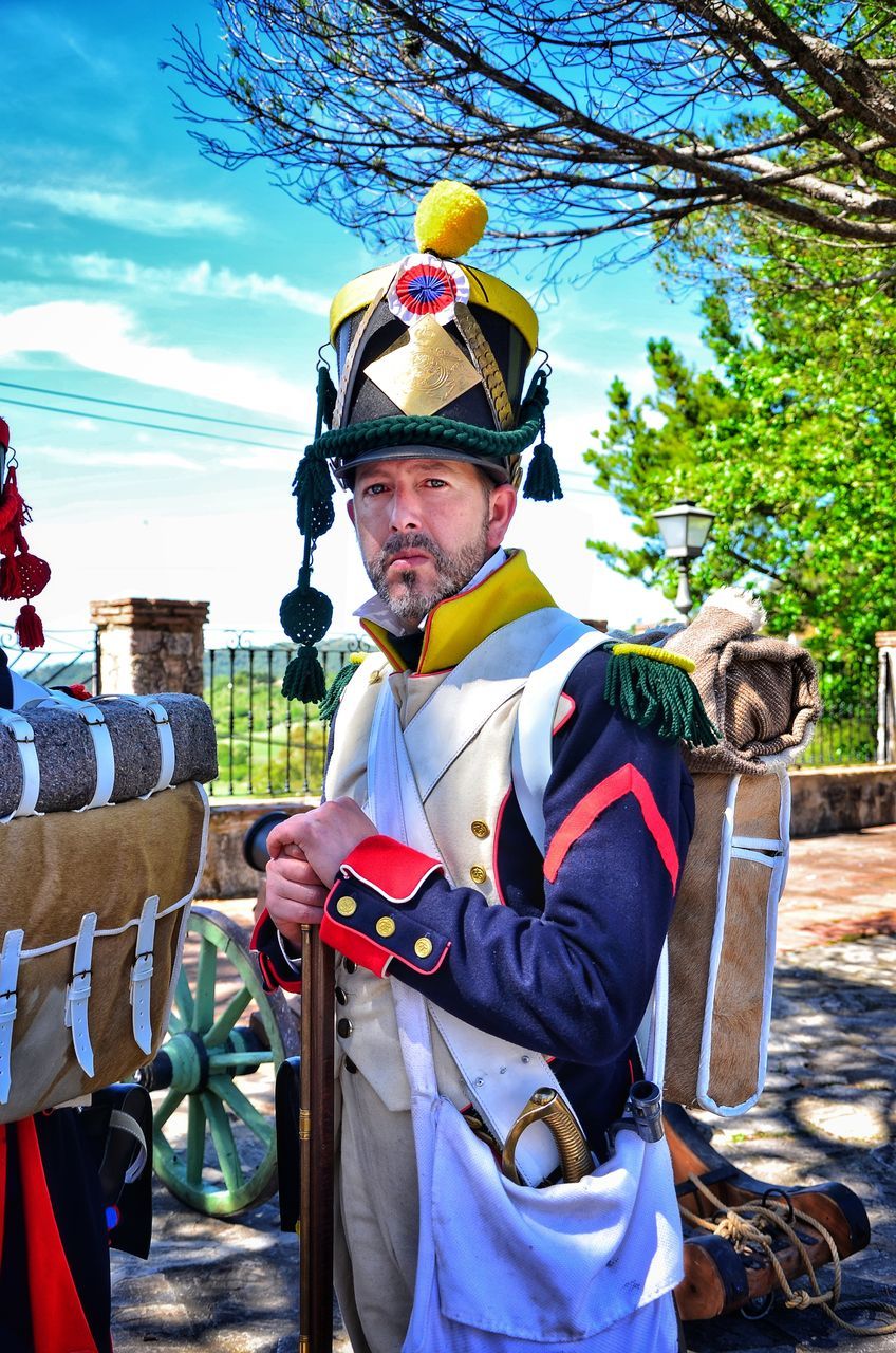 real people, one person, mature adult, mature men, standing, one animal, outdoors, day, uniform, tree, animal themes, mammal, portrait, helmet, headwear, axe, sky, people