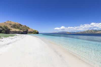 Scenic view of beach against blue sky