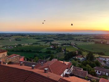 Aerial view of houses against sky during sunset