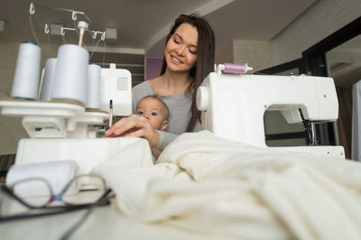 Portrait of happy mother and daughter on bed