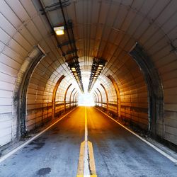 Railroad tracks in illuminated tunnel