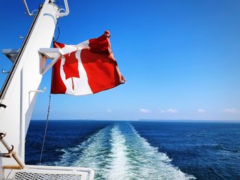 Flag on sea against blue sky