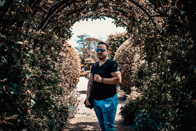 Full length portrait of man standing by tree