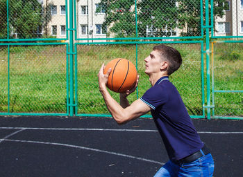 Man playing with basketball at court