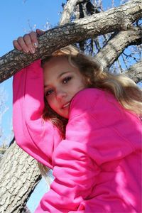 Close-up portrait of happy girl against tree trunk