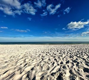 Scenic view of beach against blue sky