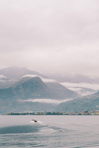 Scenic view of sea and mountains against sky