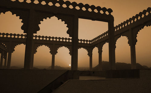 Low angle view of built structures against sky during sunset