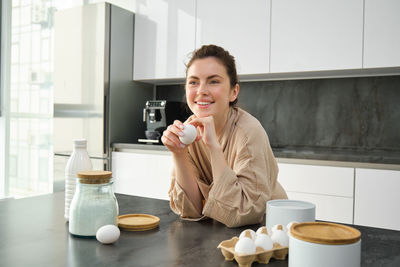 Young woman drinking milk at home