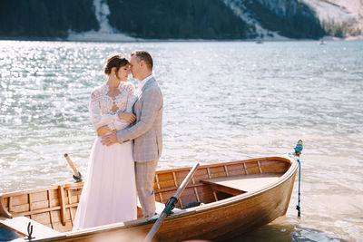 Couple standing on boat in lake