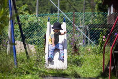 Full length of boy sliding on slide at playground