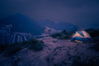 Man traveler taking photo on top of mountains near of tent camping