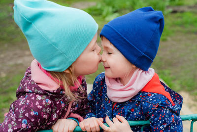 One girl kisses another on the nose. the sisters love and support each other. 