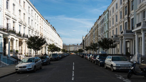 Cars on road against sky in city